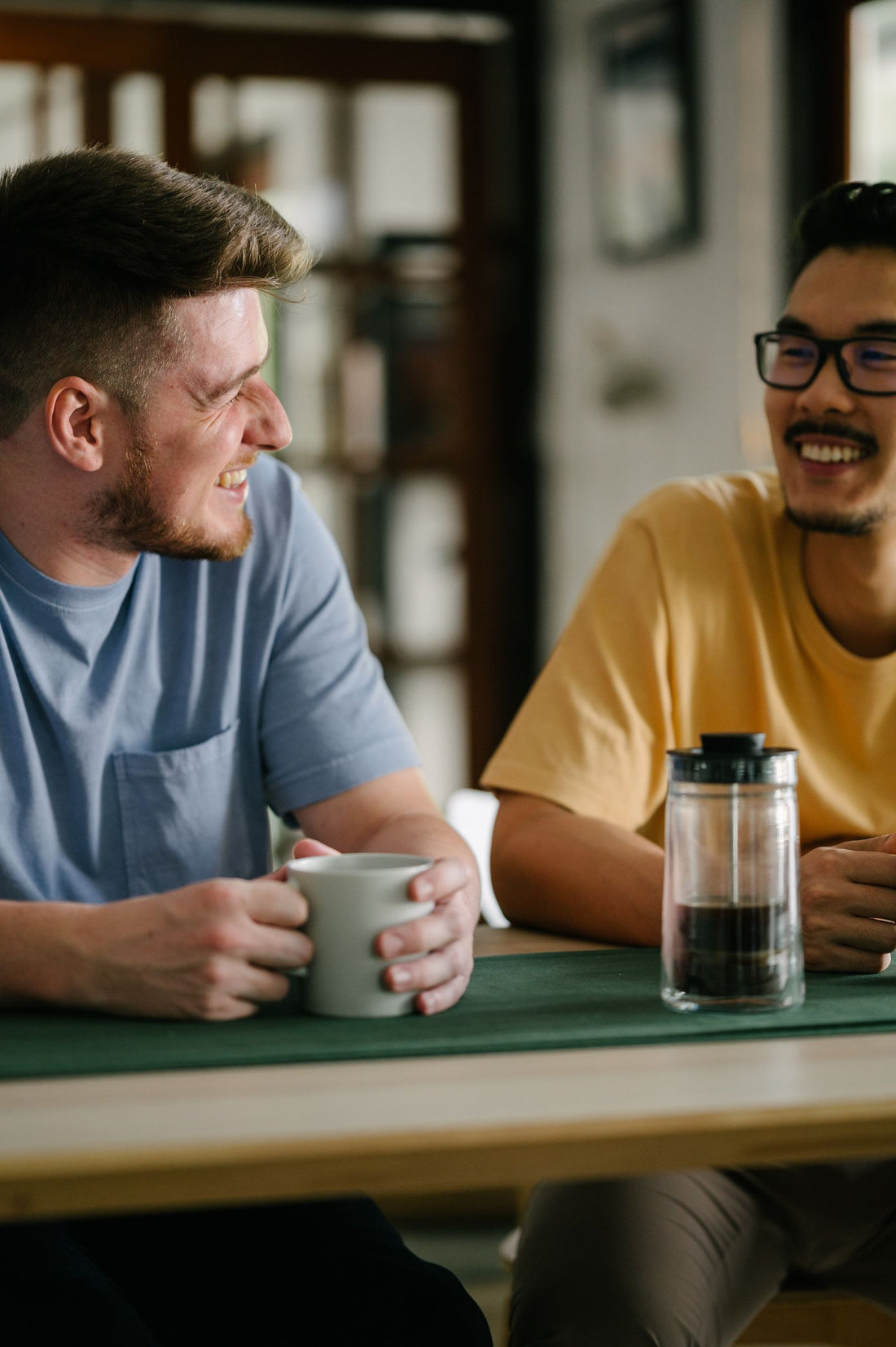 Two friends laughing together over coffee